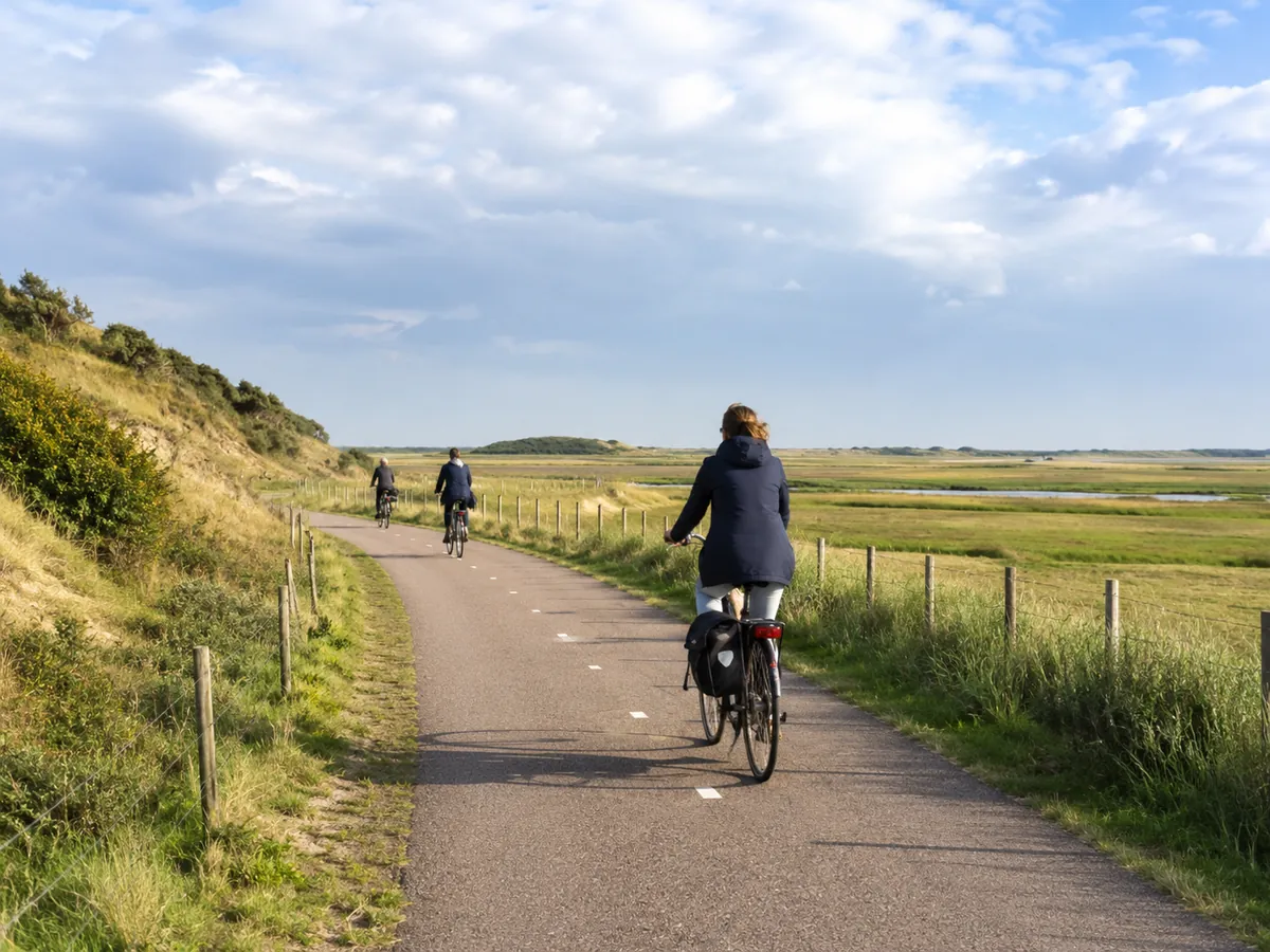 Fahrradfahren in Holland auf einem Radweg durch Dünen und weite Landschaft